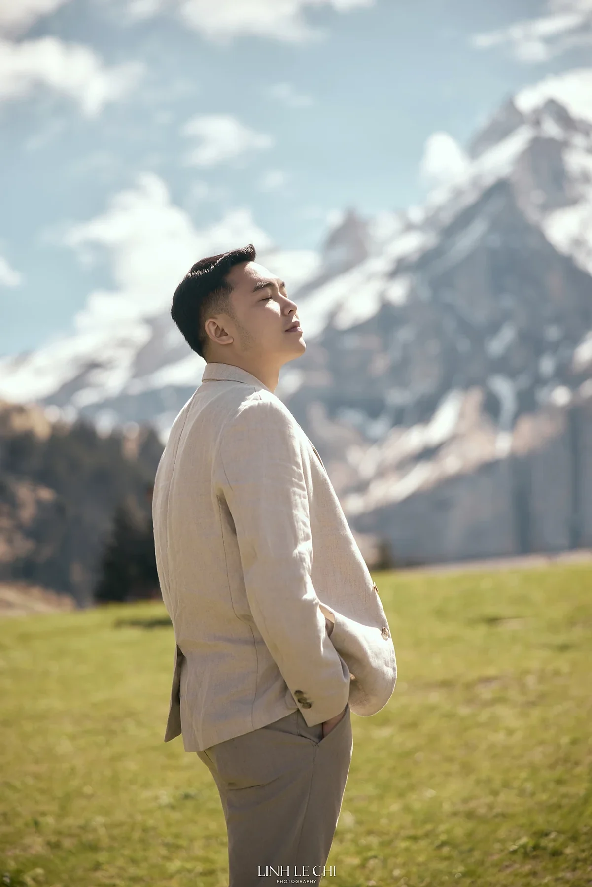 Nguyen Ba Luc in a linen suit before snowy mountains